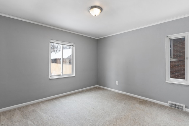 empty room featuring carpet floors, ornamental molding, visible vents, and baseboards