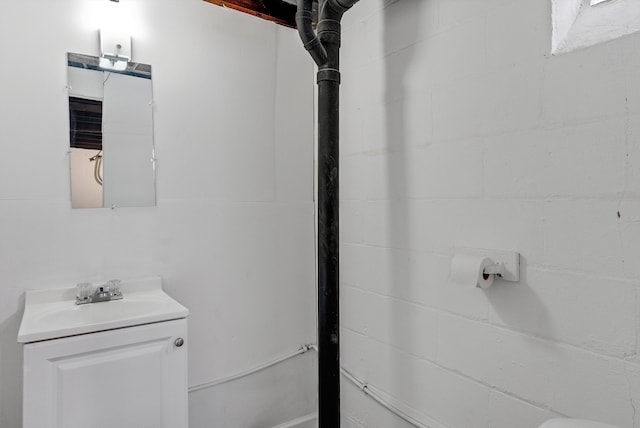 bathroom featuring vanity and concrete block wall