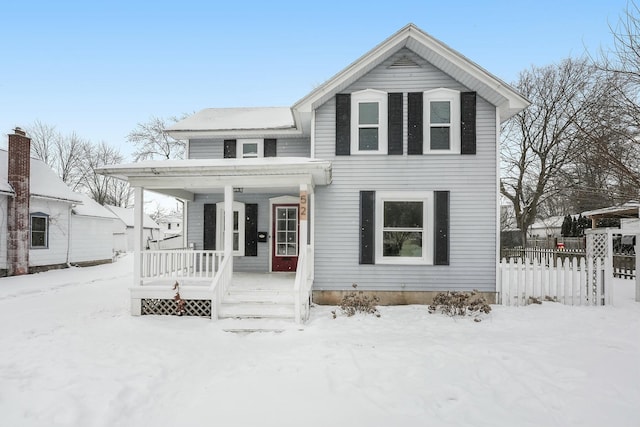 traditional-style house featuring covered porch and fence