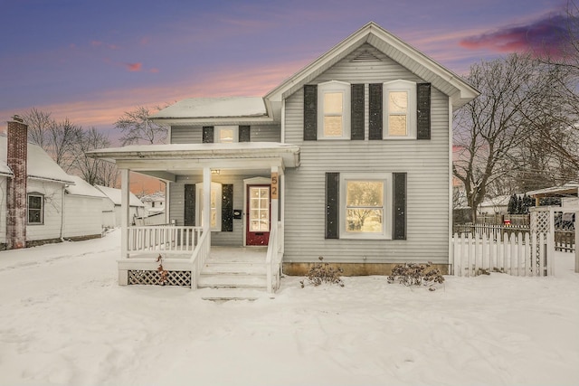 traditional home with covered porch and fence