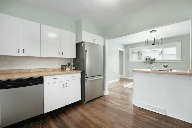 kitchen featuring visible vents, white cabinets, appliances with stainless steel finishes, dark wood-style flooring, and decorative light fixtures