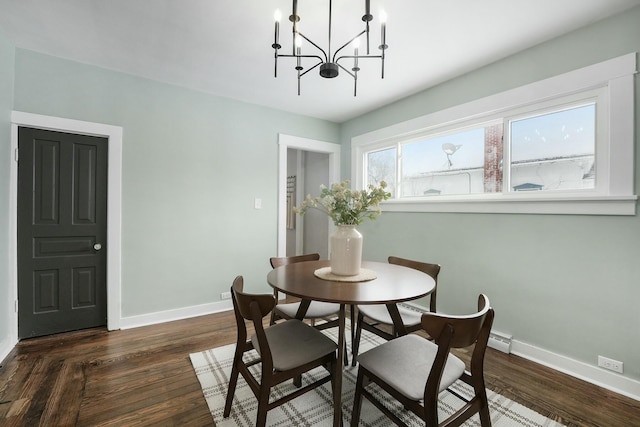 dining room featuring a chandelier, a baseboard radiator, dark wood finished floors, and baseboards