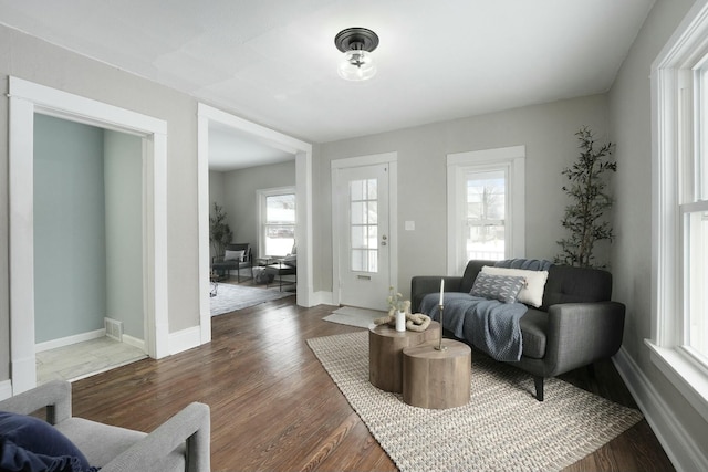 interior space with dark wood-style floors, visible vents, and baseboards