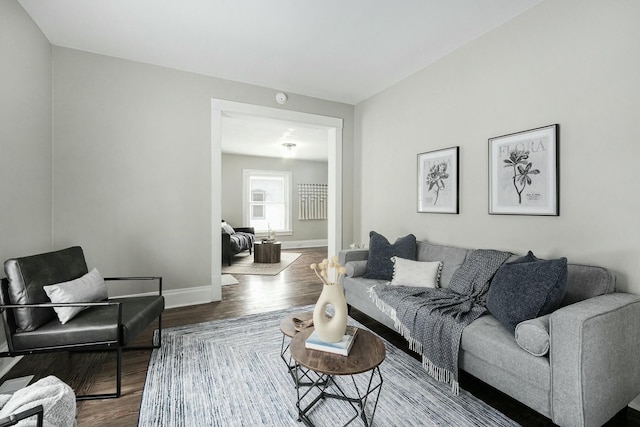 living area with baseboards and wood finished floors