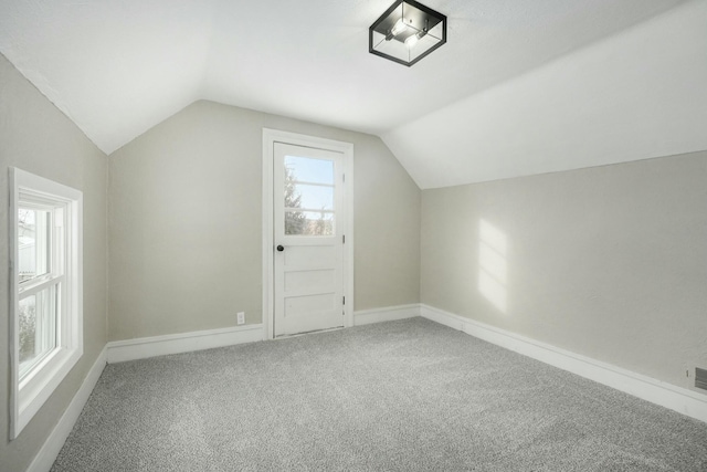 additional living space featuring lofted ceiling, carpet flooring, and baseboards