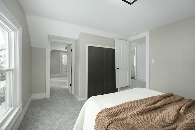 bedroom featuring light carpet, a closet, and baseboards