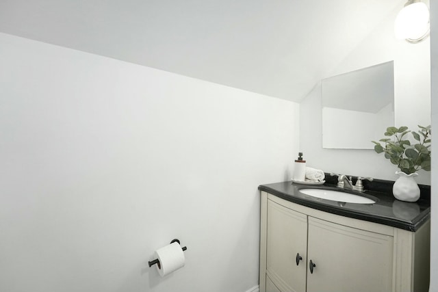 bathroom with lofted ceiling and vanity