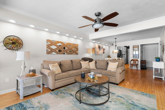 living room with recessed lighting, wood finished floors, a ceiling fan, baseboards, and crown molding