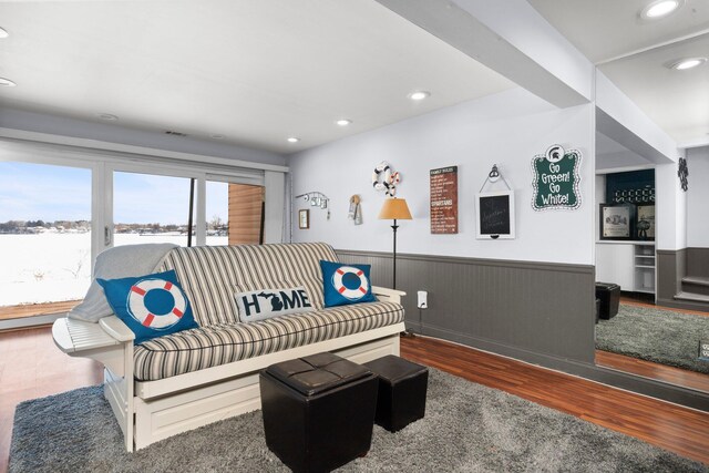 living area featuring recessed lighting, dark wood-style flooring, and a wainscoted wall