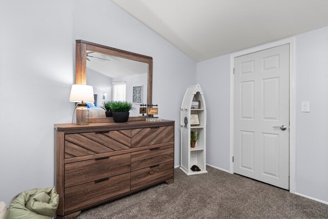 bedroom with lofted ceiling, baseboards, and dark carpet