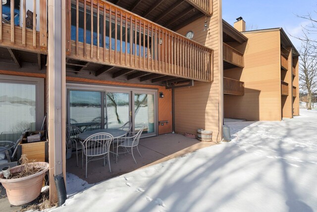 snow covered patio with a balcony