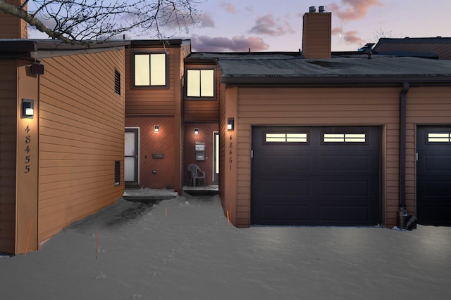 exterior space with a garage and a chimney