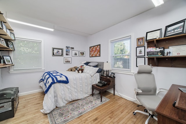 bedroom with light wood-style flooring and baseboards