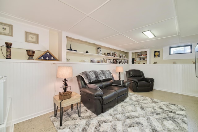 living room with built in shelves and speckled floor