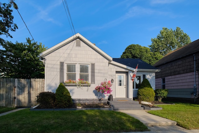 view of front of house with fence and a front lawn