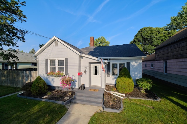 bungalow featuring a front yard, roof with shingles, fence, and a chimney