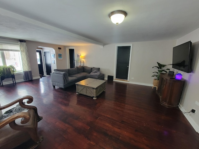 living room with dark wood-style floors, baseboards, and arched walkways