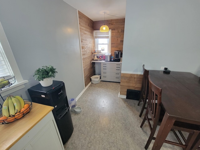 office featuring wood walls, baseboards, and light floors