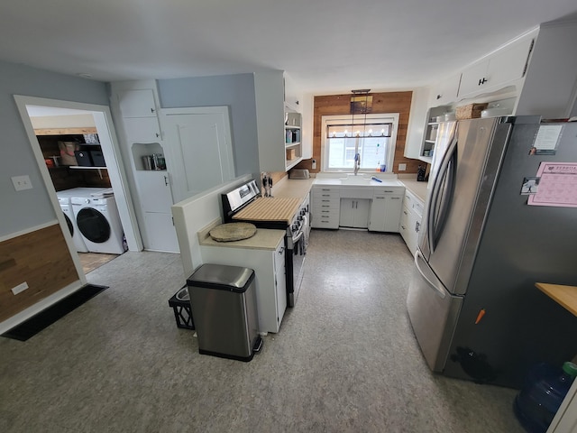 kitchen with decorative light fixtures, washer and clothes dryer, stainless steel appliances, light countertops, and white cabinets