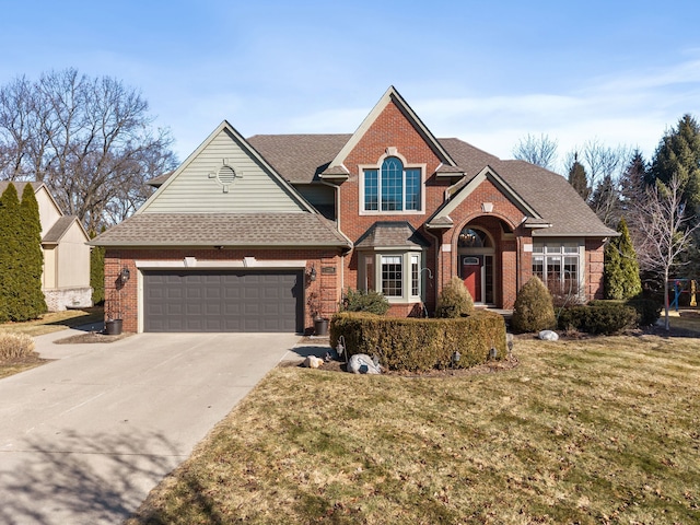 traditional home featuring brick siding, an attached garage, concrete driveway, and a front lawn