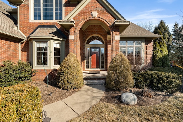 property entrance with brick siding and roof with shingles