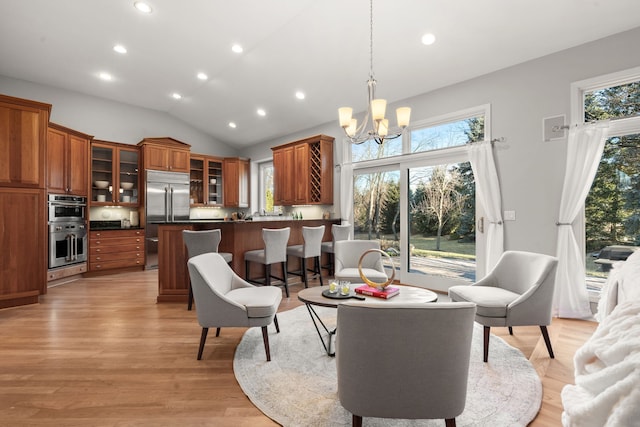 living area featuring light wood finished floors, recessed lighting, an inviting chandelier, and vaulted ceiling