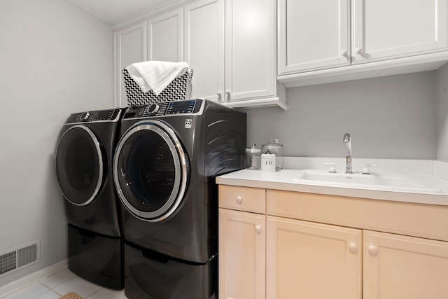 laundry room with visible vents, a sink, cabinet space, separate washer and dryer, and light tile patterned floors