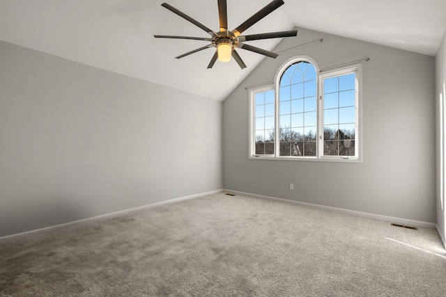 carpeted empty room with visible vents, baseboards, a ceiling fan, and vaulted ceiling