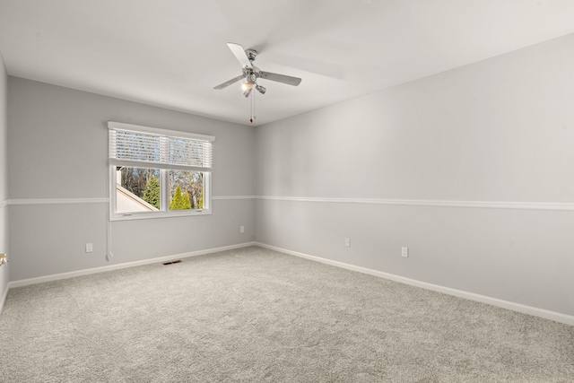 unfurnished room with carpet flooring, visible vents, baseboards, and a ceiling fan