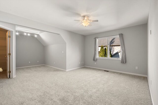 additional living space with visible vents, lofted ceiling, a ceiling fan, carpet, and baseboards