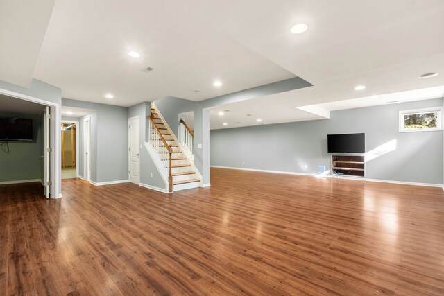 basement featuring stairway, baseboards, and wood finished floors