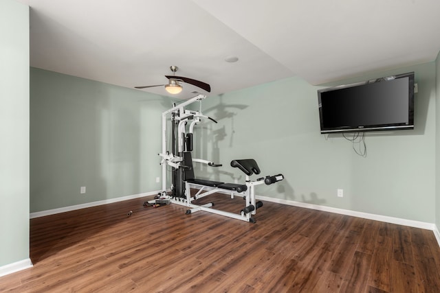 workout room featuring a ceiling fan, baseboards, and wood finished floors