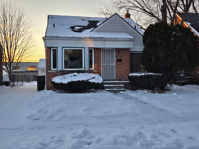 view of front of property with brick siding and a chimney