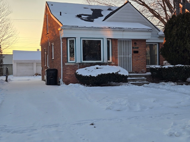 view of front of house featuring a garage, an outbuilding, and brick siding