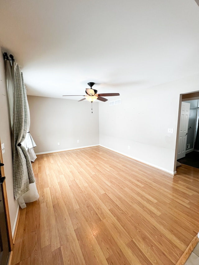 unfurnished living room featuring a ceiling fan, light wood-type flooring, visible vents, and baseboards