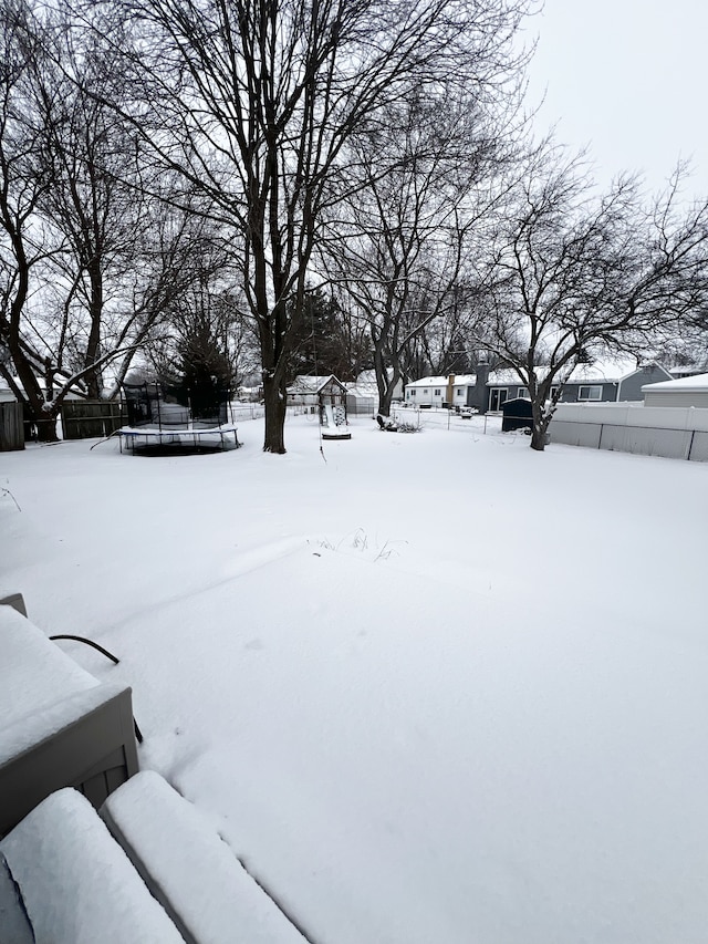 snowy yard featuring fence