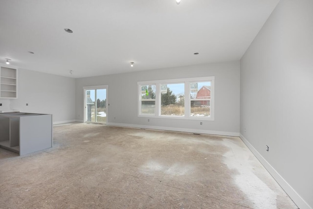 unfurnished living room featuring baseboards