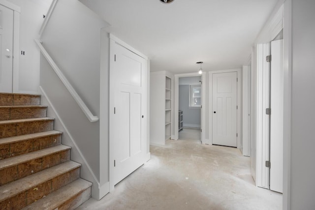 interior space featuring stairway and unfinished concrete floors