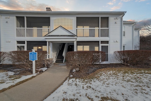 snow covered property with stairway