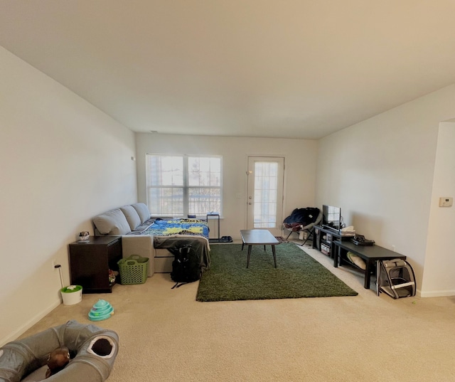 carpeted living area with baseboards