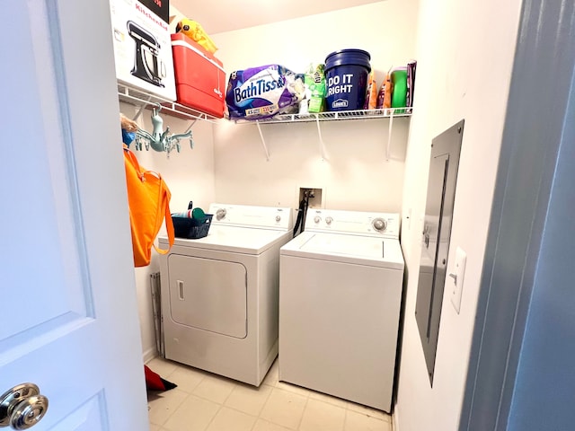 clothes washing area featuring laundry area, washer and dryer, and light tile patterned flooring