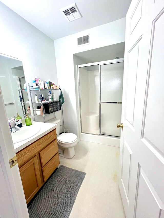 full bathroom with toilet, a stall shower, vanity, and visible vents