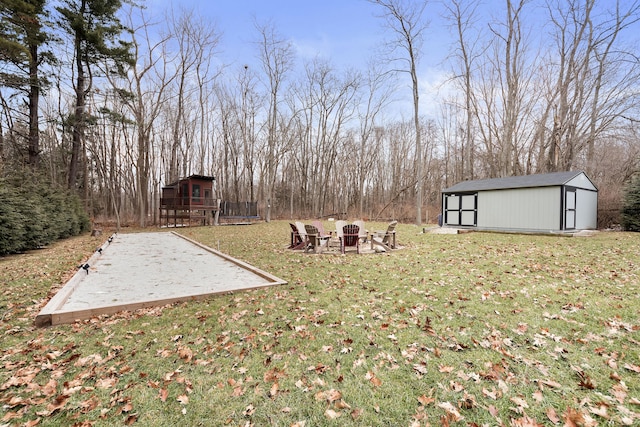 view of yard featuring an outdoor structure and a fire pit