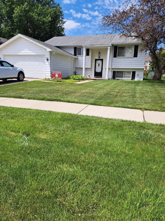 bi-level home featuring a garage, a shingled roof, and a front lawn