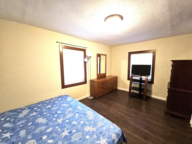 bedroom featuring dark wood-type flooring, a textured ceiling, and baseboards