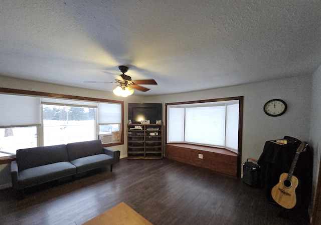 living area with dark wood-style floors, ceiling fan, and a textured ceiling