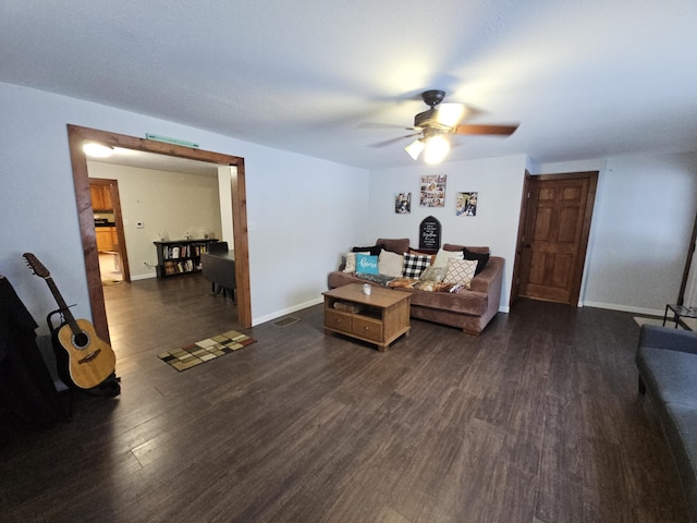 living room featuring dark wood-style floors, baseboards, and a ceiling fan