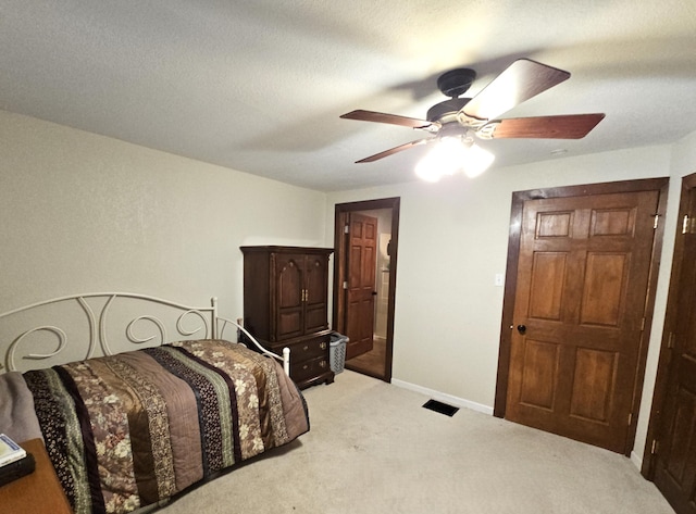 bedroom with light colored carpet, ceiling fan, a textured ceiling, and baseboards