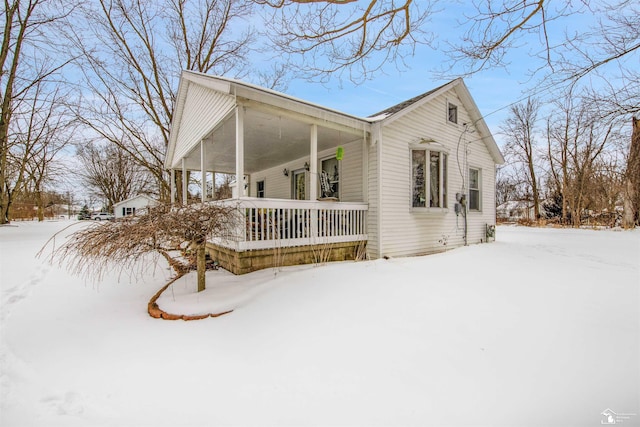 snow covered property with a porch