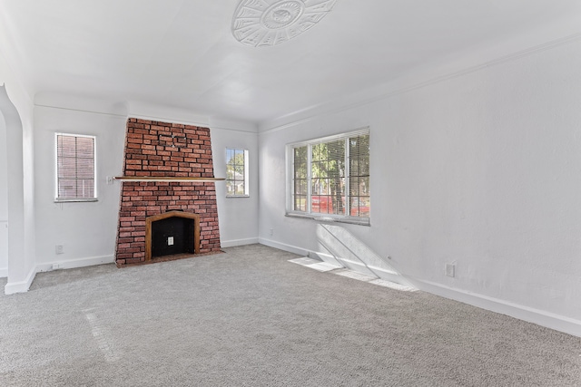 unfurnished living room with carpet, a fireplace, and baseboards